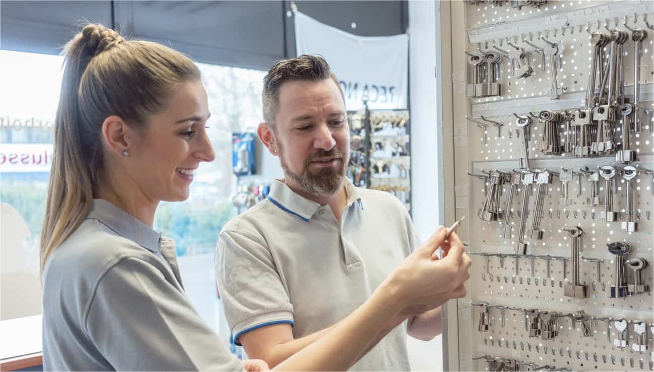 A locksmith helping a customer at a key counter